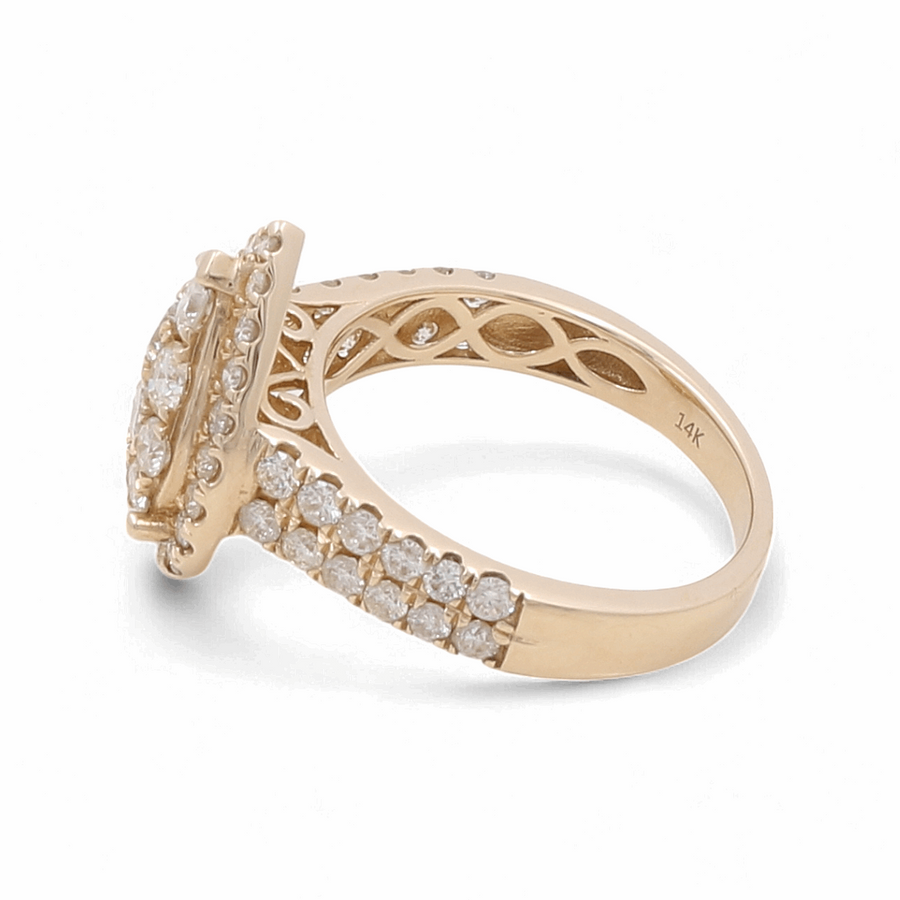 The 14K Yellow Gold Bridal Woman Ring with Diamonds by Miral Jewelry is a bridal set beautifully crafted from yellow 14 karat gold. It features a gold band adorned with numerous small white diamonds and a stunning cluster of larger diamonds on top, engraved with "14K" inside the band.