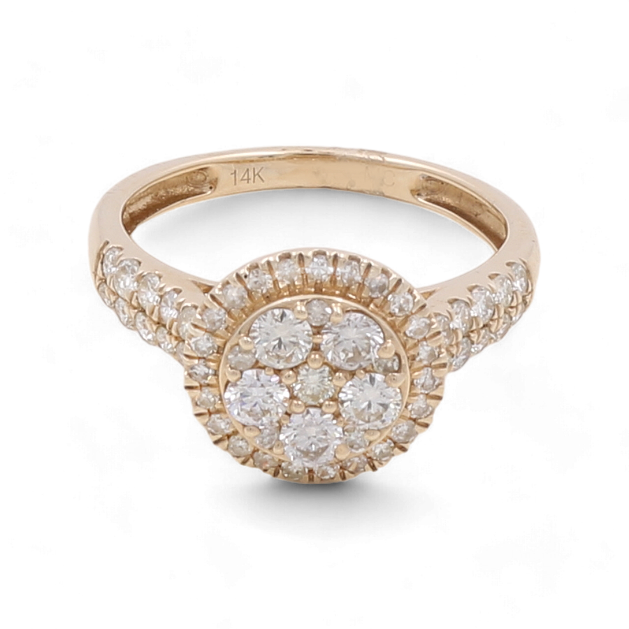 Introducing the 14K Yellow Gold Bridal Woman Ring with Diamonds by Miral Jewelry. This stunning ring showcases a round cluster of small diamonds set at the center, enhanced by additional diamonds encrusting the band. Ideal for engagements or anniversaries, it is marked with "14K" to signify its quality.