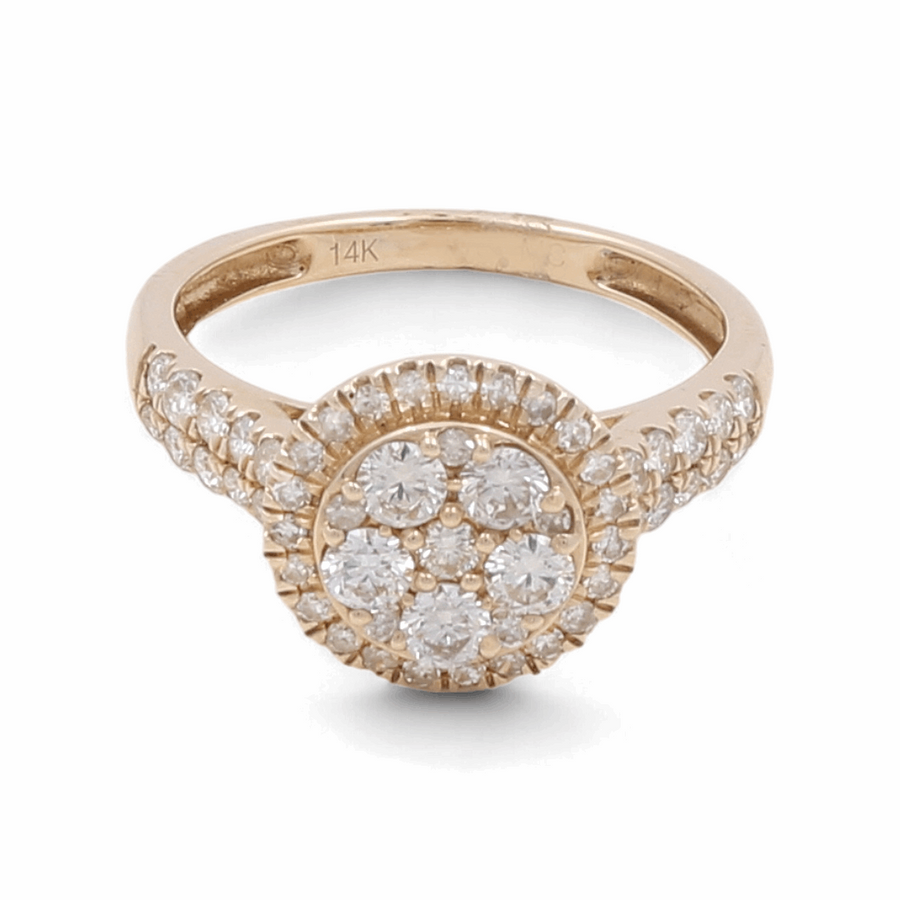 Introducing the 14K Yellow Gold Bridal Woman Ring with Diamonds by Miral Jewelry. This stunning ring showcases a round cluster of small diamonds set at the center, enhanced by additional diamonds encrusting the band. Ideal for engagements or anniversaries, it is marked with "14K" to signify its quality.