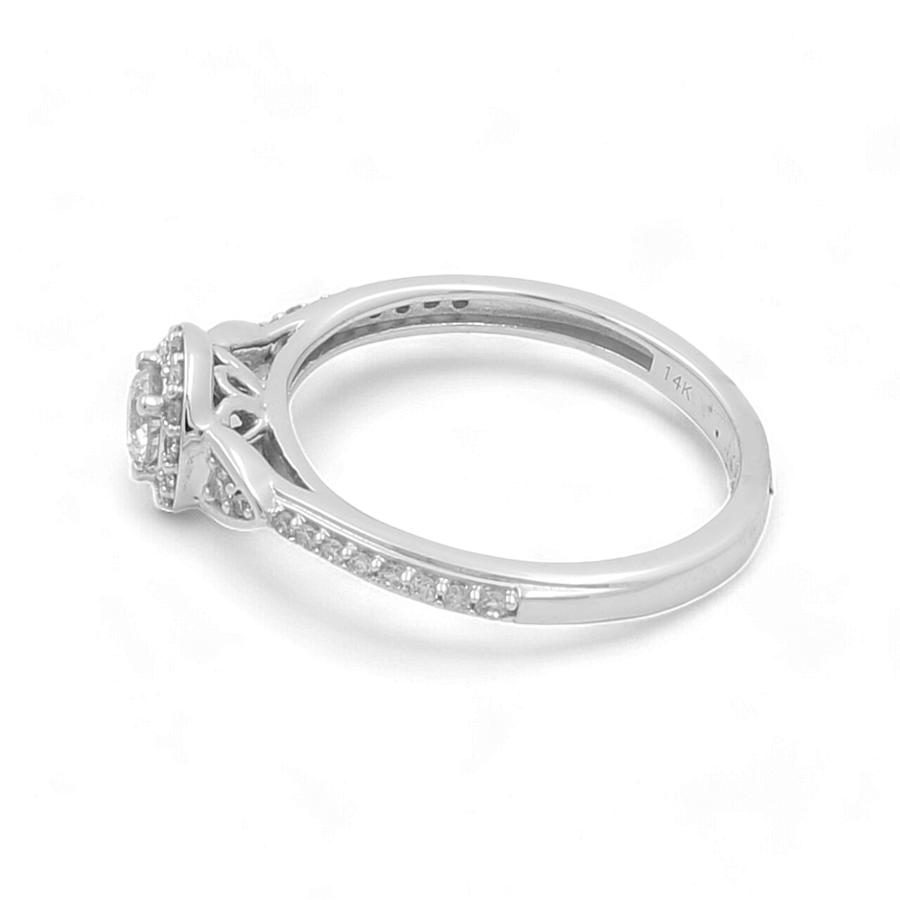 The Miral Jewelry 14K White Gold Bridal Woman Ring with Diamonds features a breathtaking round diamond centerpiece and smaller diamonds adorning the band, all set against a white background. The inside of the band is engraved with "14K," making it an ideal choice for any bride's special day.