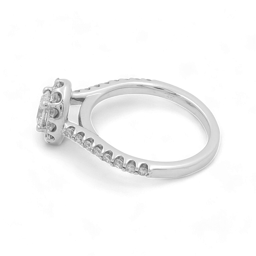 The 14K White Gold Bridal Woman Ring with Diamonds by Miral Jewelry features a stunning raised, square-shaped setting adorned with multiple small diamonds and additional smaller diamonds embedded along the sides of the band.