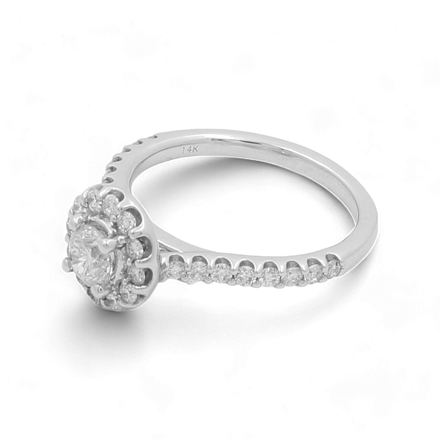 The Miral Jewelry 14K White Gold Bridal Woman Ring with Diamonds showcases a central round diamond encircled by a halo of smaller diamonds, with additional diamonds encrusted along the band.