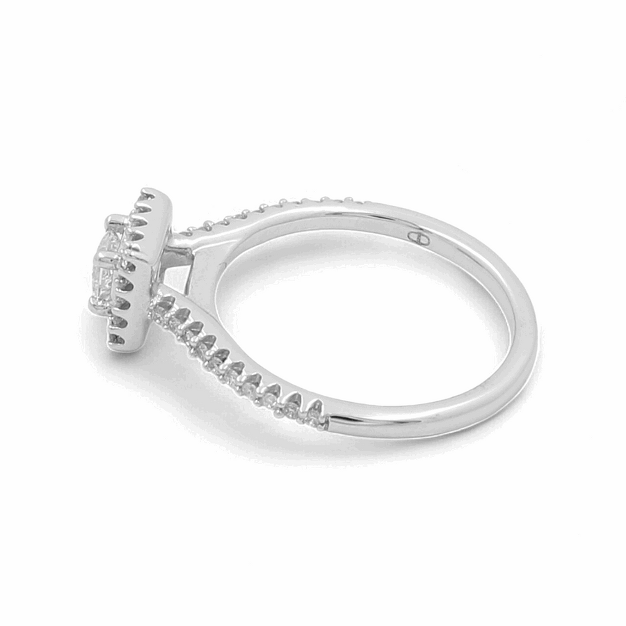 This exquisite 14K white gold bridal ring from Miral Jewelry features a prong-set central gemstone, elegantly accented with small diamonds lining the band.