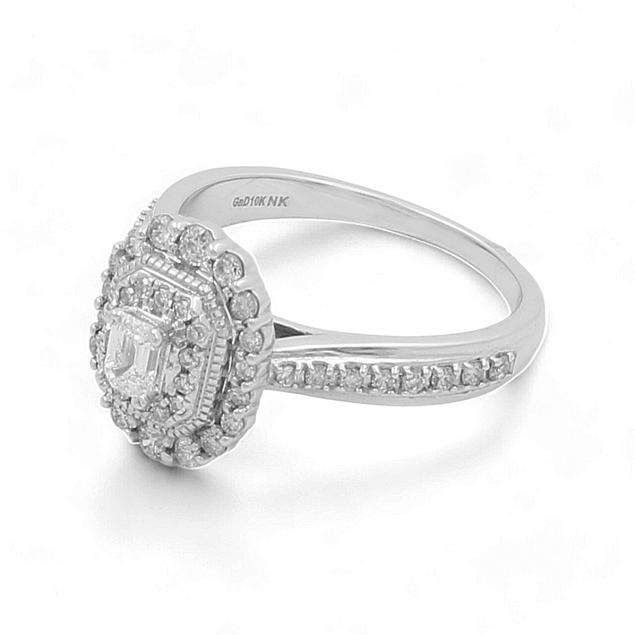 The 10K White Gold Bridal Woman Ring with Diamonds by Miral Jewelry is a striking engagement piece featuring a central 1 carat diamond encased in a hexagonal setting, accentuated by smaller diamonds and complemented by a diamond-studded band.