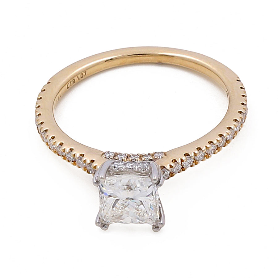 A 14K Yellow Gold Women's Contemporary Engagement Ring with 0.26Tw Round Diamonds by Miral Jewelry, featuring a large square-cut diamond at the center and a band adorned with smaller diamonds.