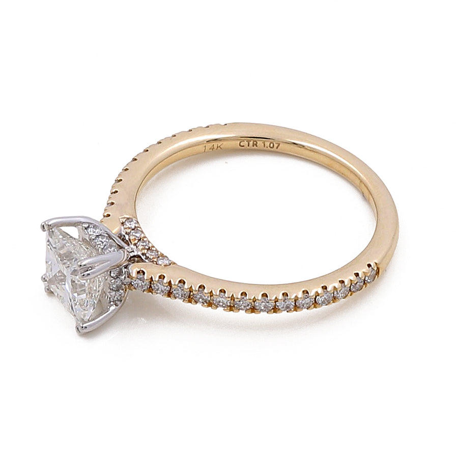 The Miral Jewelry 14K Yellow Gold Women's Contemporary Engagement Ring with 0.26Tw Round Diamonds features a large square-cut diamond in a prong setting with smaller diamonds lining the band, offering a touch of modern elegance to this contemporary engagement ring.