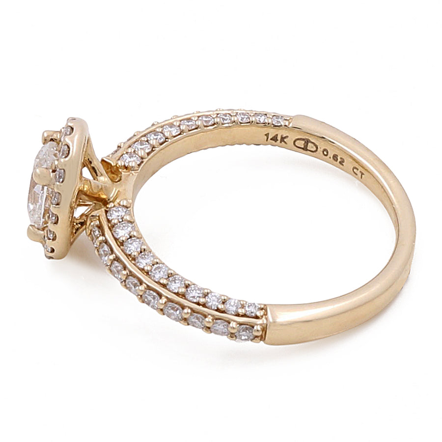The 14K Yellow Gold Women's Contemporary Engagement Ring 0.62Tw Oval Diamonds-0.54Tw Round Diamonds by Miral Jewelry is crafted in 14K yellow gold, featuring a round central diamond and smaller round diamonds encrusted on the band, stamped with "14K" and "0.62 CT" on the inner side.