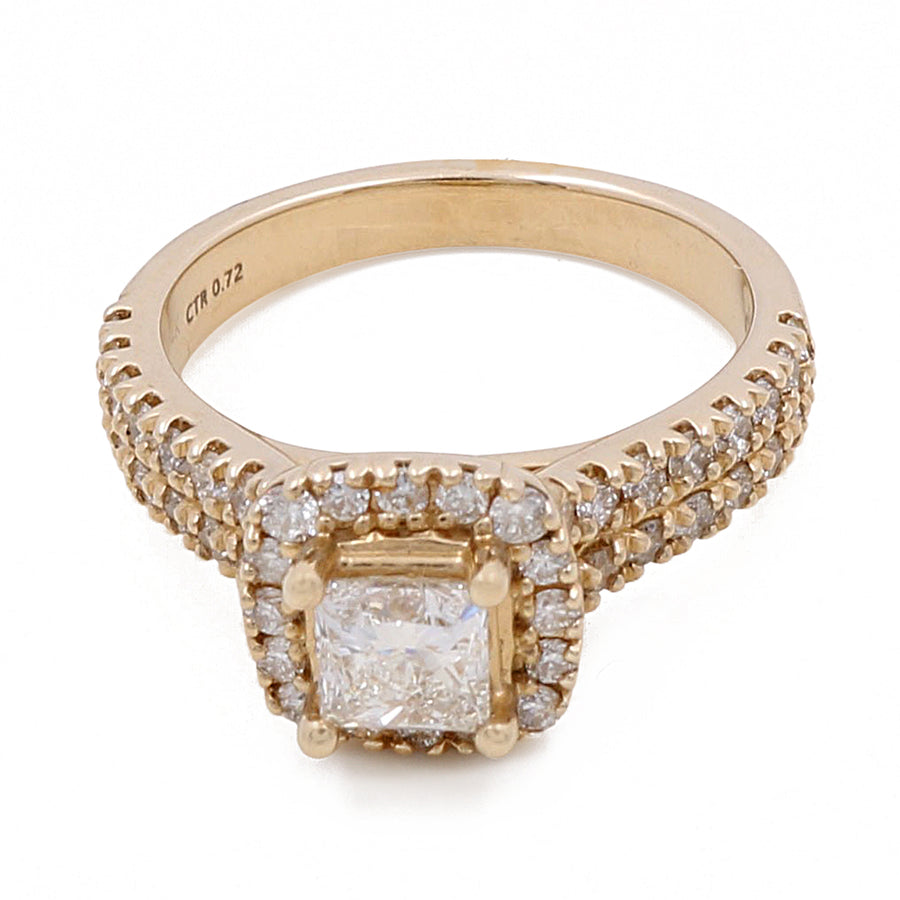 A 14K Yellow Gold Women's Contemporary Engagement Ring with 0.75Tw Round Diamonds by Miral Jewelry with a square center diamond surrounded by smaller round diamonds and additional diamonds along the band. The 0.72 CT diamond is inscribed on the inside of this contemporary engagement ring.