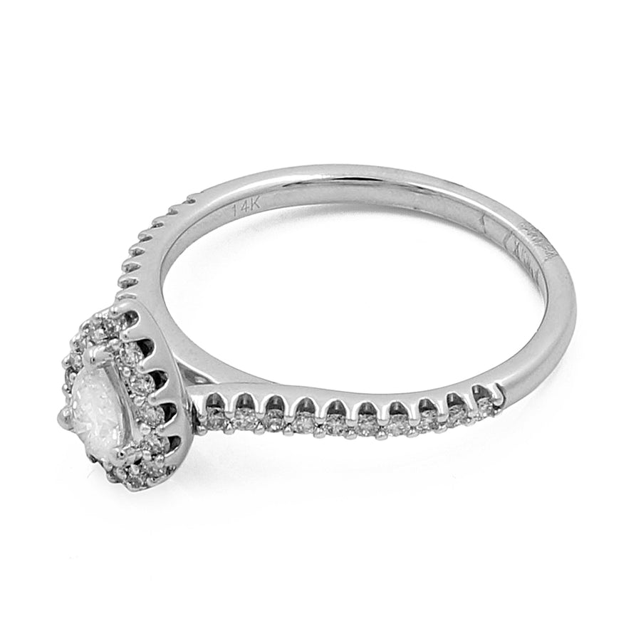 Side view of a silver 14K White Gold Women's Contemporary Engagement Pear Ring 0.50Tw Round Diamonds by Miral Jewelry, featuring a central oval-shaped diamond surrounded by smaller round diamonds on the band and halo setting.
