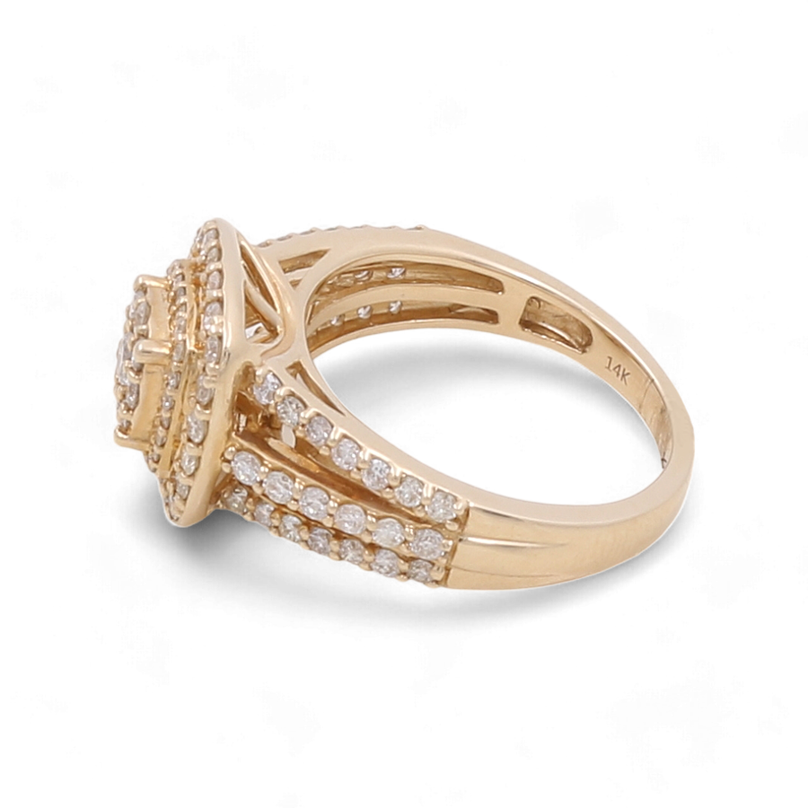 Photograph of a luxurious 14K Yellow Gold Bridal Woman Ring with Diamonds by Miral Jewelry. The band splits into two sections, each encrusted with rows of small diamonds. The center features a large, raised diamond surrounded by smaller ones, epitomizing elegance and sophistication.