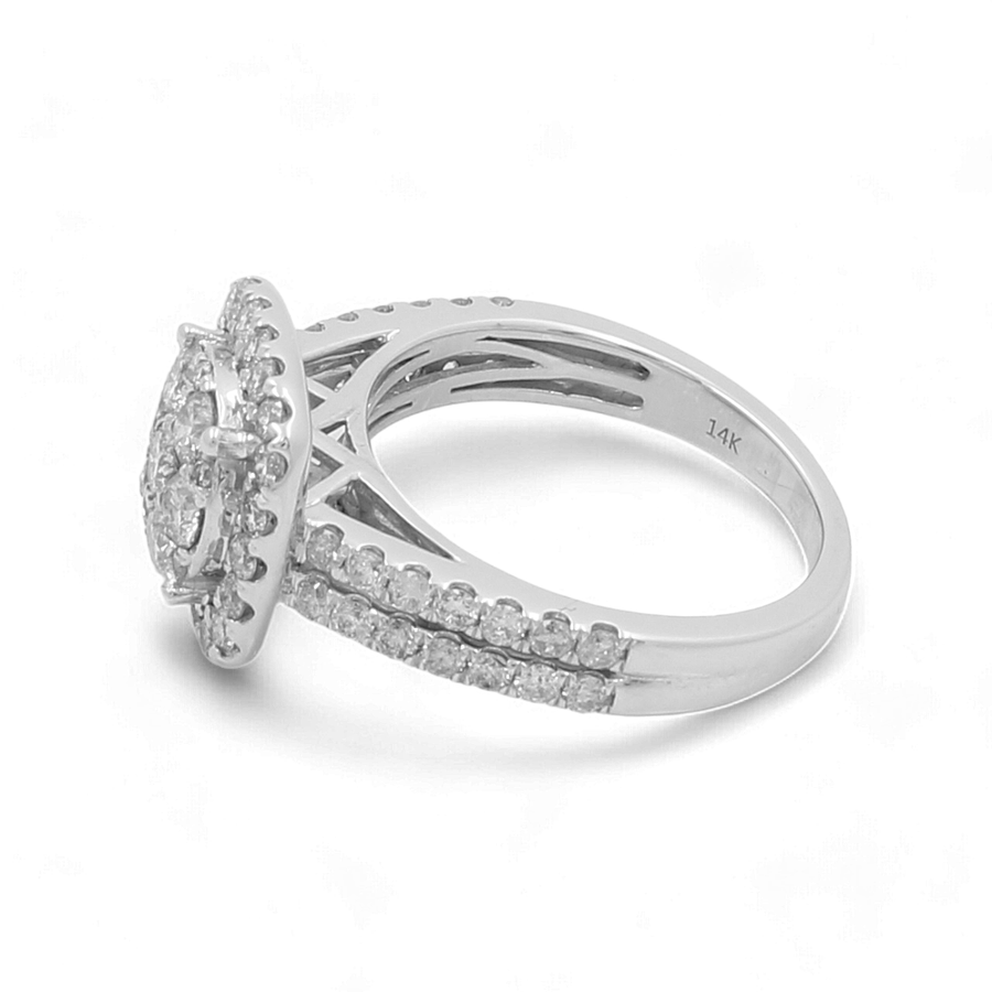 The 14K White Gold Bridal Woman Ring with Diamonds by Miral Jewelry features a round cluster of small diamonds set on top, with additional diamonds encrusted along the split band. The inside of the band is engraved with "14K".