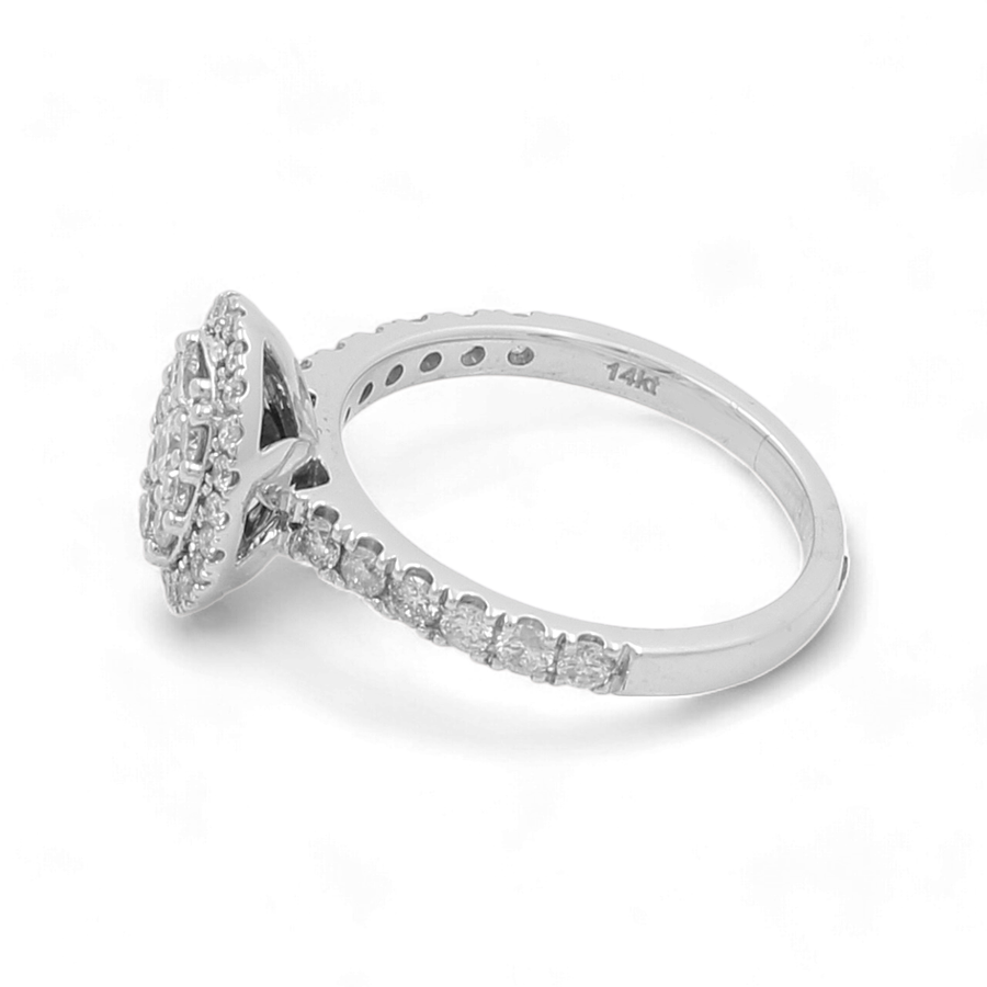 A close-up side view of the 14K White Gold Bridal Woman Ring with Diamonds by Miral Jewelry showcases a central round-cut diamond with smaller diamonds embedded along the band. The inside of this luxury band is engraved with "14K".