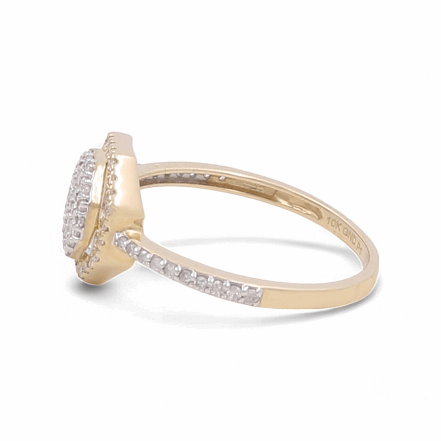 A dazzling bridal ring by Miral Jewelry, crafted from 10K yellow gold and featuring an elegant band adorned with a series of small diamonds, culminating in a raised square-shaped setting with a cluster of sparkling diamonds.