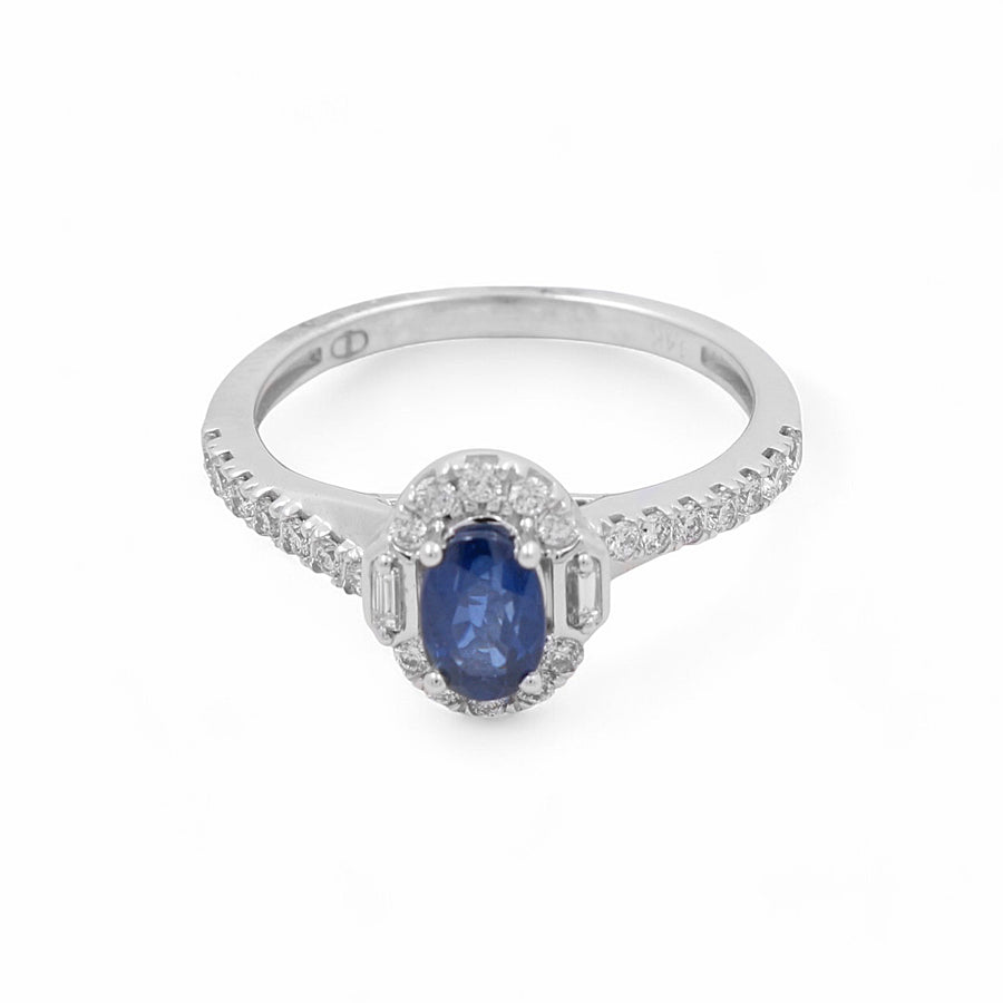 A stunning 14K white gold bridal ring from Miral Jewelry, featuring a blue oval sapphire surrounded by small diamonds on the band and around the gemstone, shown on a white background.