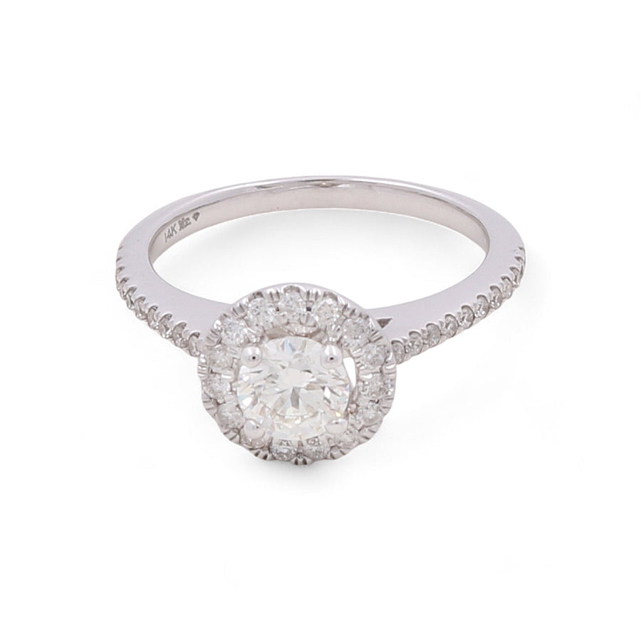 The Miral Jewelry 14K White Gold Women's Contemporary Engagement Ring boasts a round diamond centerpiece, surrounded by smaller diamonds and set on a diamond-studded band.