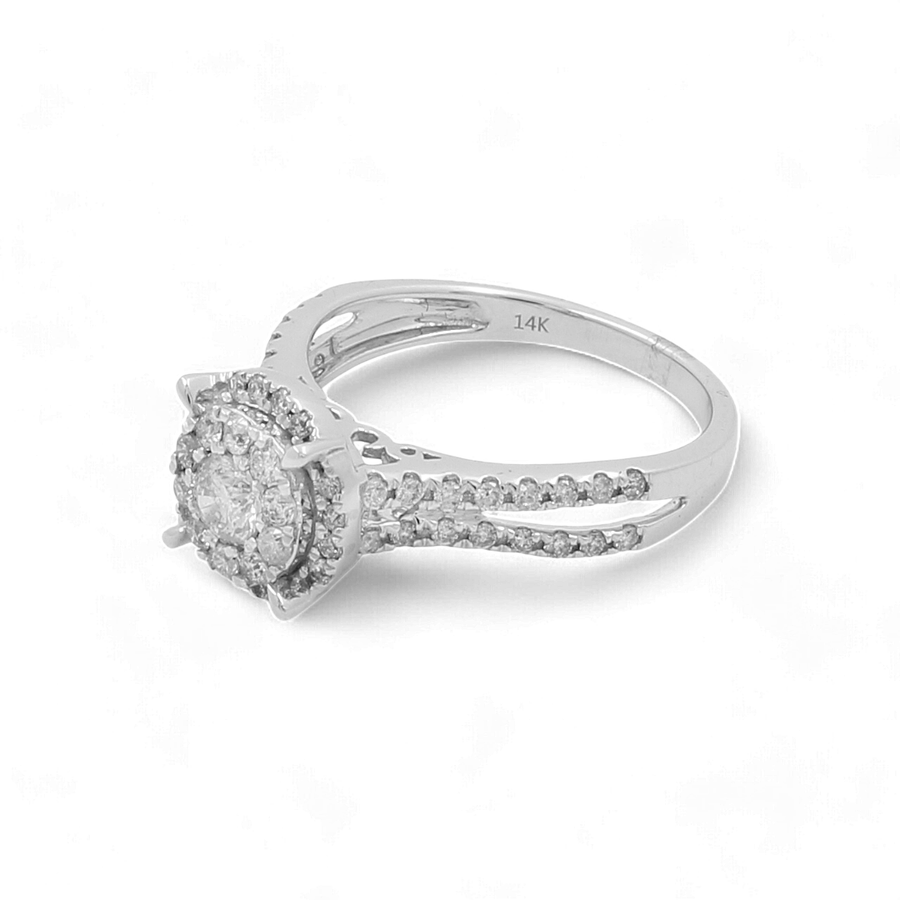 Introducing the 14K White Gold Women's Contemporary Engagement Ring by Miral Jewelry, with a round halo-setting encrusted with small diamonds and a split-shank band adorned with additional round diamonds—an exquisite choice for an engagement ring.