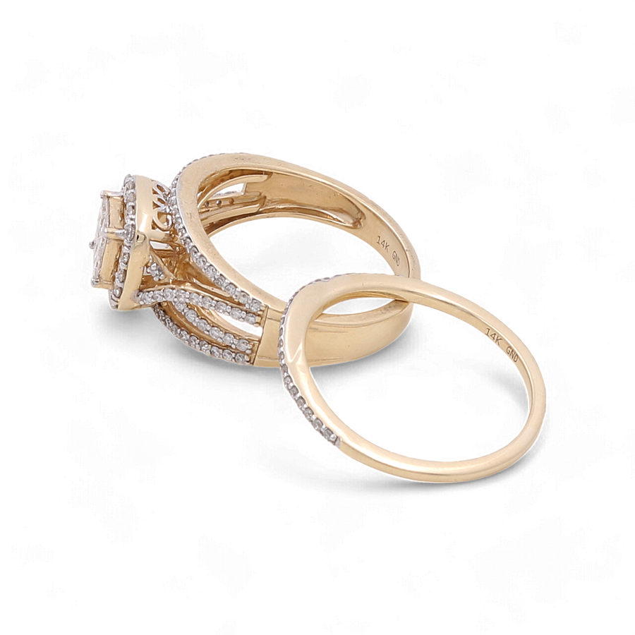 Two elegant and timeless rings are displayed on a plain white background. The first is a stunning 14K Yellow Gold Bridal Woman Ring with Diamonds from Miral Jewelry, featuring a large central diamond complemented by smaller diamonds along the band. The second ring, crafted from 14K white gold, boasts a simpler design with smaller diamonds set around its band.