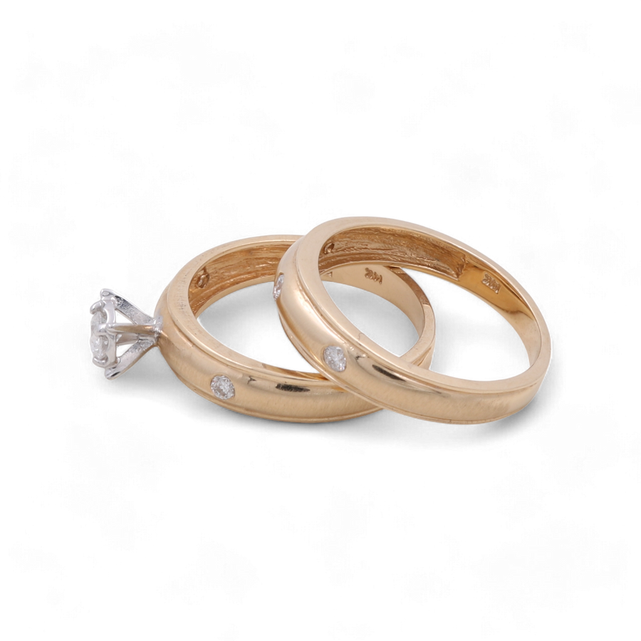 Two 14K yellow gold wedding bands by Miral Jewelry, each adorned with small diamonds, and one Miral Jewelry 14K Yellow Gold Bridal Woman Ring featuring a single large diamond, displayed against a plain background. Ideal for the discerning woman seeking the perfect bridal ring set.