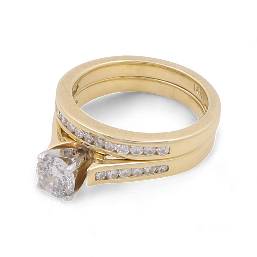 Here’s a revised version of the sentence:

A 10K yellow gold bridal ring from Miral Jewelry, adorned with a prominent diamond and featuring a matching gold wedding band, each embellished with small diamonds.