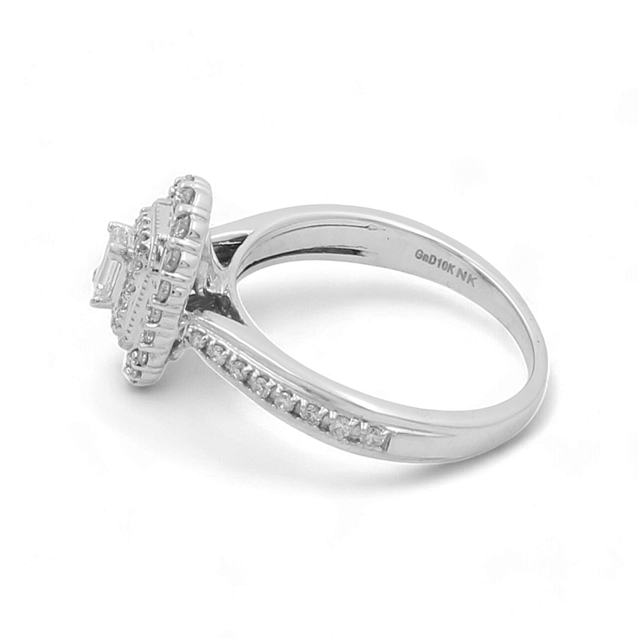 The 10K White Gold Bridal Woman Ring with Diamonds by Miral Jewelry features a central rectangular gemstone surrounded by sparkling diamonds on an elevated setting, with additional stones set along the band, showcasing an elegant design perfect for a bridal ring.