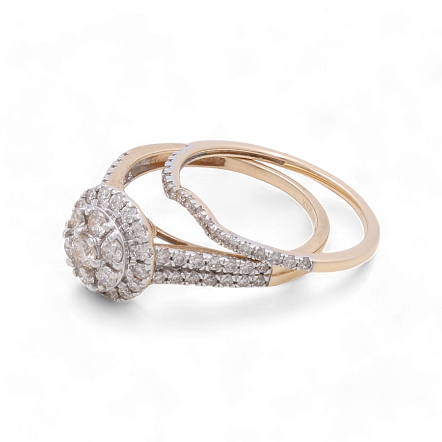 The 14K Yellow Gold Bridal Woman Ring with Diamonds by Miral Jewelry showcases an intertwined design and a circular diamond cluster centerpiece, elegantly adorned with small round diamonds.