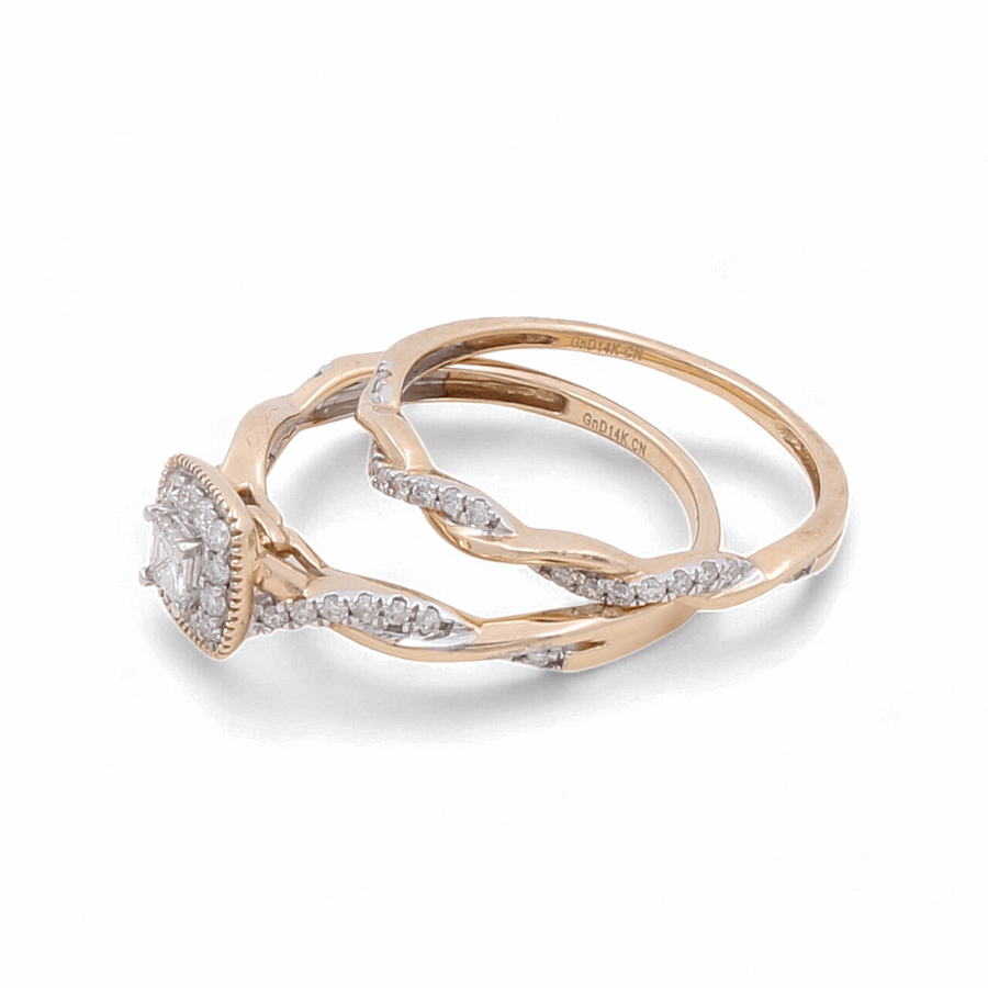 Two 14K Yellow Gold Bridal Woman Rings from Miral Jewelry are displayed side by side on a white background. One ring features a large central diamond encircled by smaller diamonds, while the other is a simpler band with embedded diamonds.