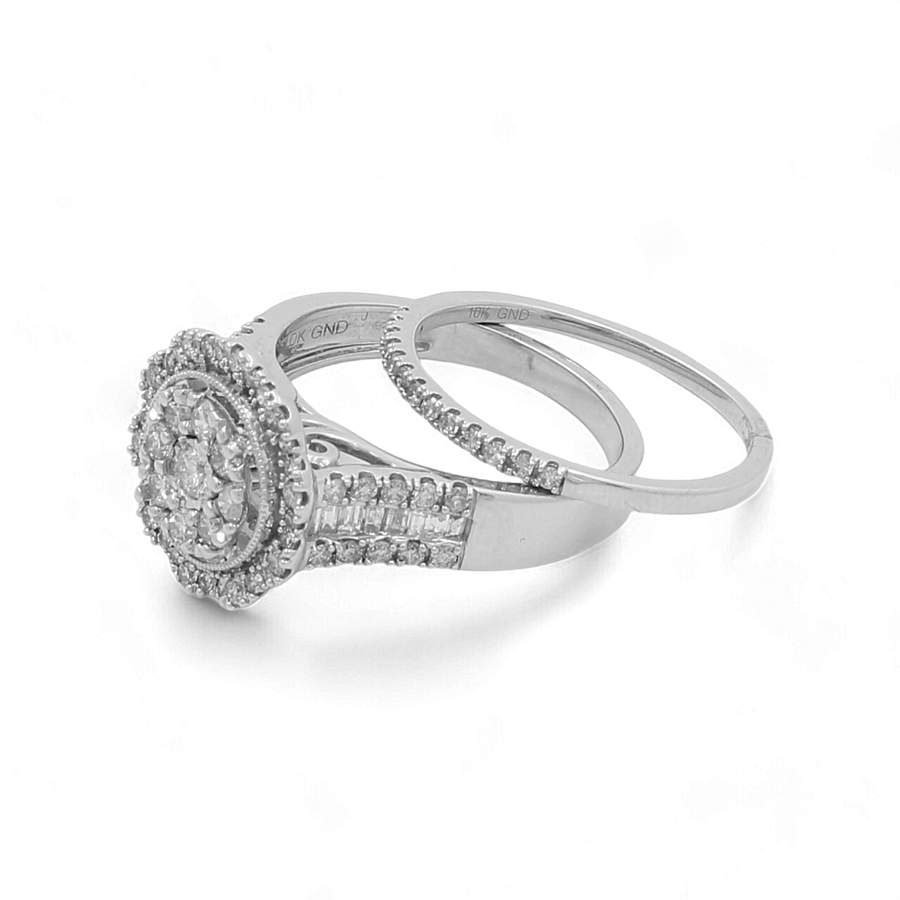 A 10K White Gold Bridal Woman Ring with Diamonds by Miral Jewelry, featuring intricate engravings and a circular diamond cluster, accompanied by a matching thin diamond band, showcasing an elegant and sophisticated design.