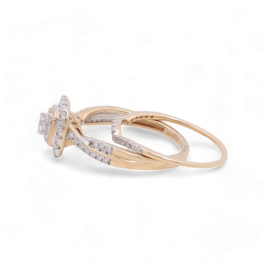 The Miral Jewelry 14K Yellow Gold Bridal Woman Ring with Diamonds showcases a flower-shaped cluster of diamonds at its center, complemented by additional sparkling diamonds adorning the band.