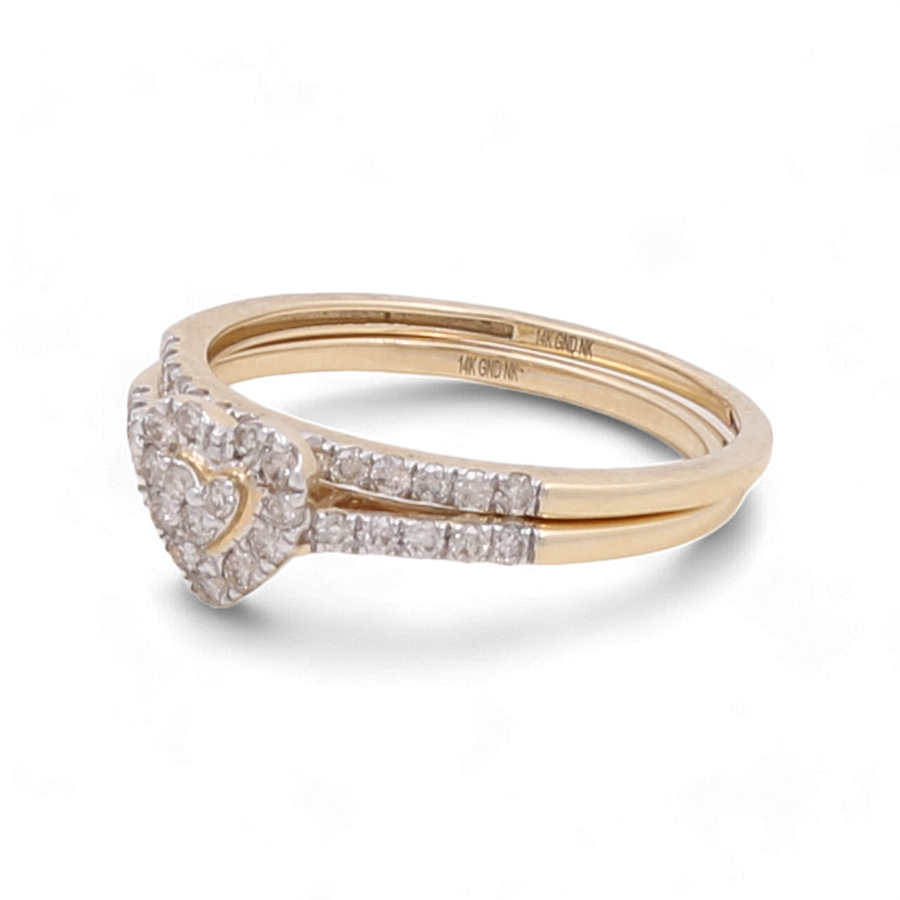 Introducing the 14K Yellow Gold Bridal Woman Ring with Diamonds by Miral Jewelry, a stunning piece featuring a heart-shaped cluster of small diamonds on top, complemented by additional diamonds set along the band, perfect for the modern woman.