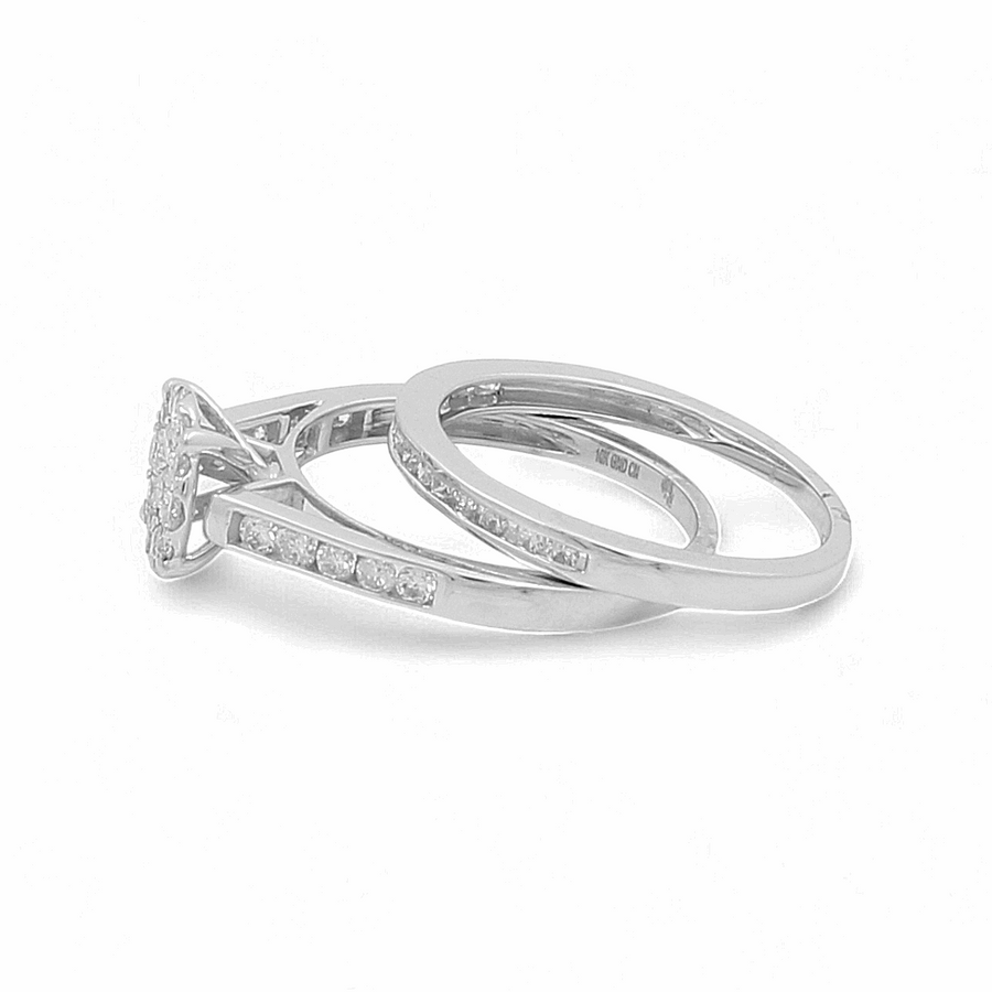 The 10K White Gold Bridal Woman Ring with Diamonds by Miral Jewelry features two interlocking rings: one adorned with a solitaire diamond and smaller diamonds along the band, and the other a plain band with inlaid diamonds, making it perfect for the bridal woman.