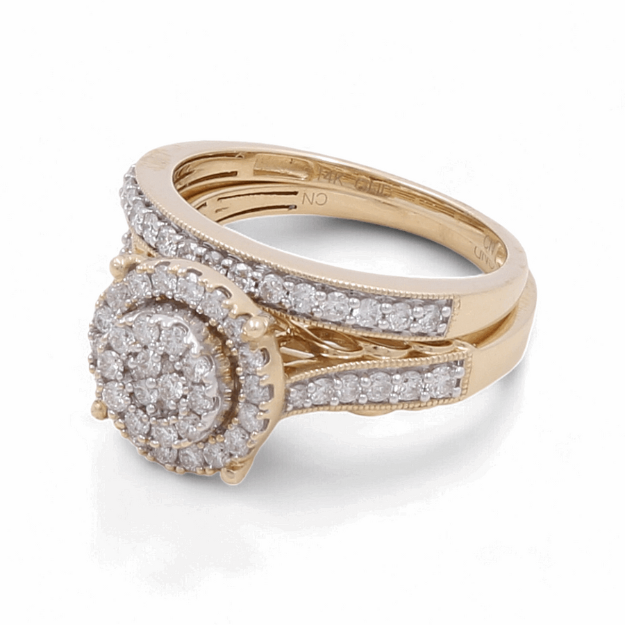 A bridal woman ring from Miral Jewelry in 14K yellow gold featuring a circular cluster of diamonds and diamond accents along the band.