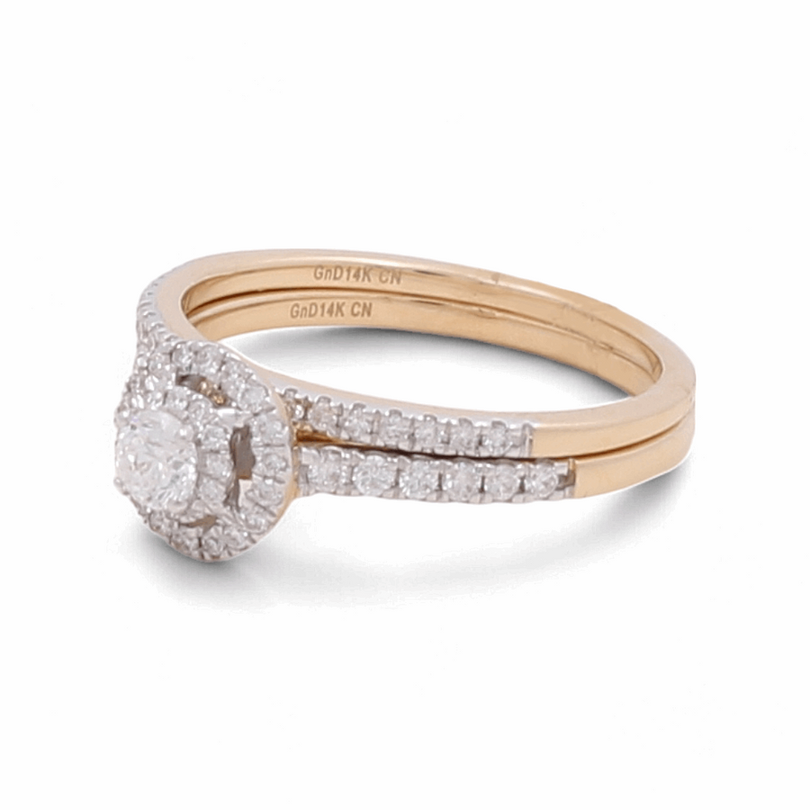 The Miral Jewelry 14K Yellow Gold Bridal Woman Ring with Diamonds features a stunning engagement ring with a central diamond encircled by smaller diamonds, accompanied by a matching wedding band. Ideal for the bridal woman, both rings are engraved with "GND14K CN" on the inner side.