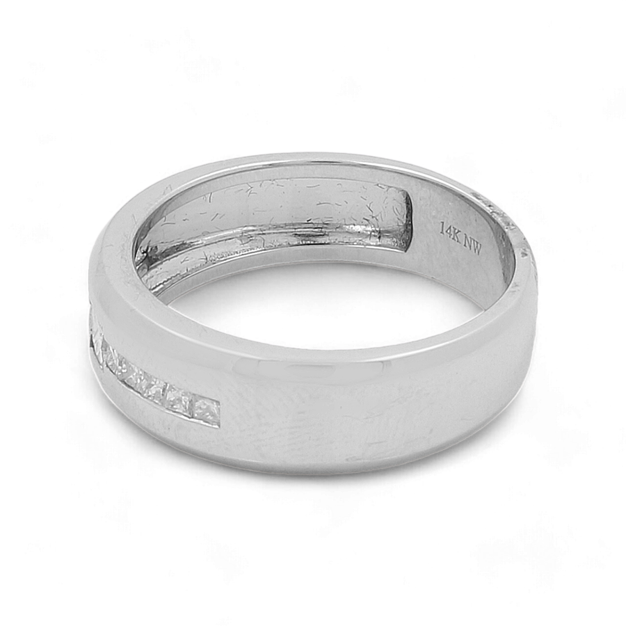 A simple yet luxurious piece, the "14K White Gold Bridal Men Ring with Diamonds" by Miral Jewelry features a smooth, slightly worn surface adorned with a row of small square-cut diamonds embedded in the band. The inside bears the engraving "14K NW," highlighting its 14K white gold composition.