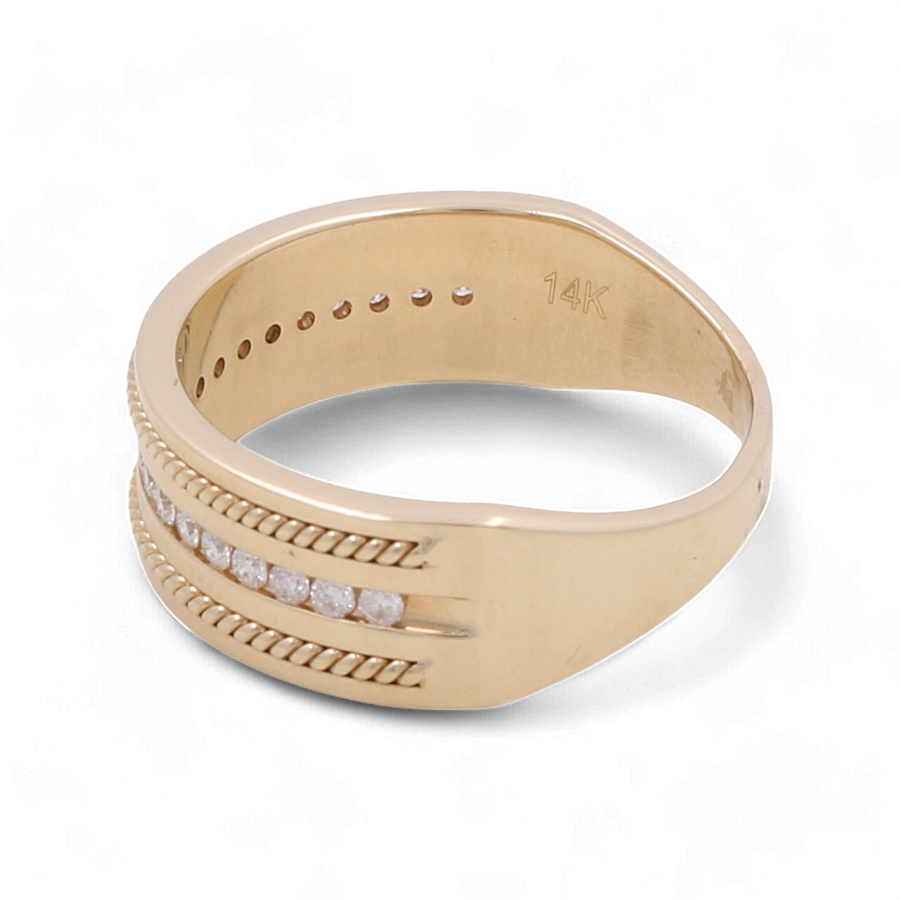 The 14K Yellow Gold Bridal Men Ring with Diamonds by Miral Jewelry features a row of diamonds set between two parallel grooves and is inscribed with "14K" on the inner band.