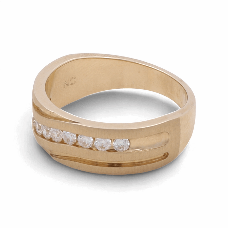 The Miral Jewelry 10K Yellow Gold Bridal Men's Ring with Diamonds boasts a modern design, characterized by a parallel groove and a row of small, sparkling diamonds. This exquisite ring also features the engraving "CN" on the inside of the band.