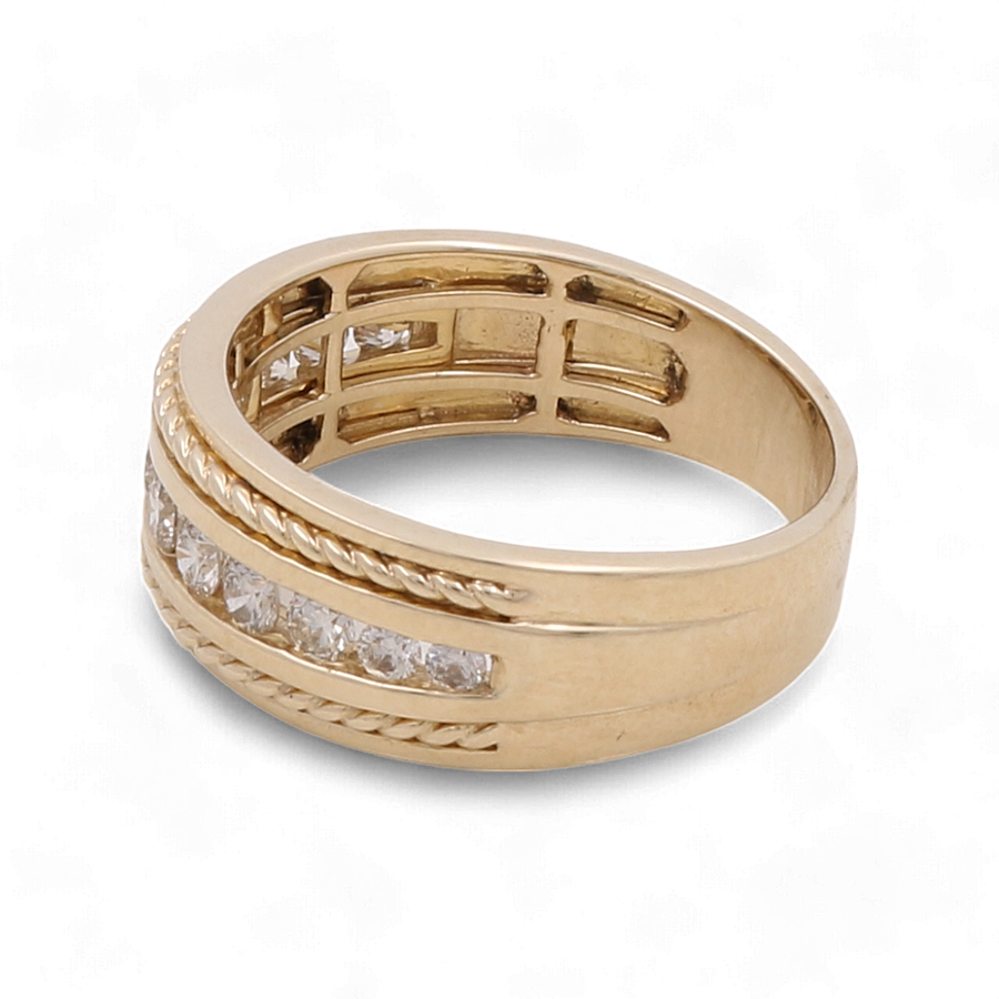 A luxurious piece from Miral Jewelry, this 10K Yellow Gold Bridal Men Ring features embedded square-cut diamonds and intricate decorative grooves.