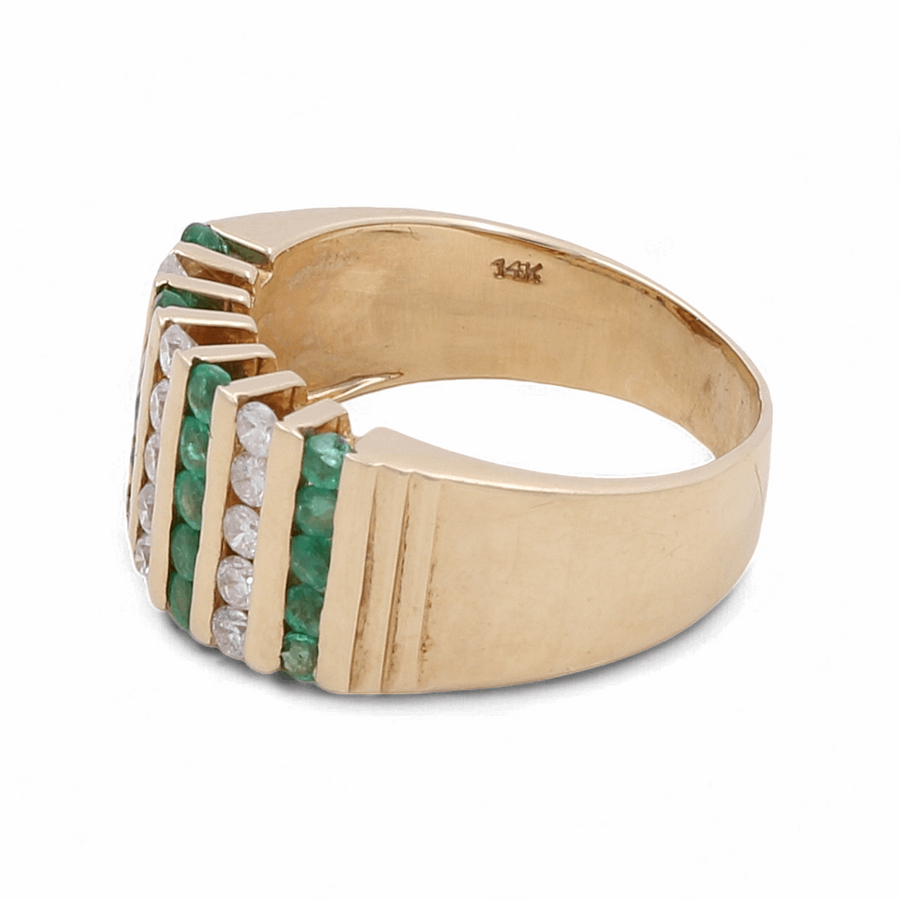 The 14K Yellow Gold Diamond Fashion Woman Ring by Miral Jewelry features alternating rows of green stones and white diamonds, a stunning 1 Ct diamond centerpiece, and a 14K inscription inside the band.