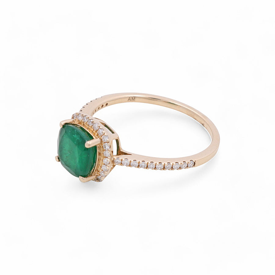 The 14K Yellow Gold Woman Fashion Ring by Miral Jewelry features a stunning large green gemstone at its center, encircled by smaller clear stones, all set against a pristine white background—an exquisite addition to any woman's fashion jewelry collection.