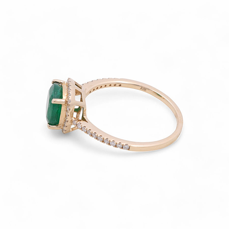 This 14K yellow gold woman fashion ring from Miral Jewelry features a striking green gemstone centerpiece and small clear stones along the band, epitomizing elegant trends in women's jewelry.