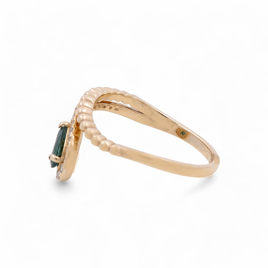 The Miral Jewelry 14K Yellow Gold Woman Fashion Ring showcases a green gemstone in a side view, featuring a beaded design on the band and delicate diamond accents.