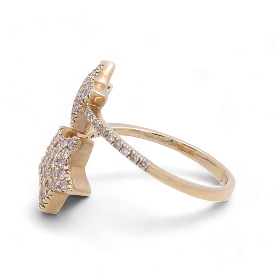 A 10K yellow gold ring by Miral Jewelry, featuring a star-shaped design and encrusted with small diamonds, displayed against a white background. This luxurious ring perfectly complements any fashion diamond woman's collection.