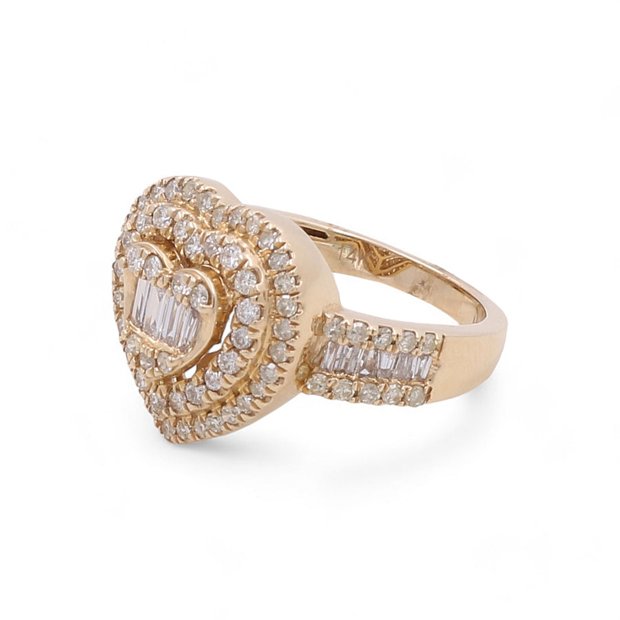 The Miral Jewelry 14K Yellow Gold Fashion Heart Diamond Women's Ring features a heart-shaped design with numerous small diamonds and a central cluster of baguette diamonds.