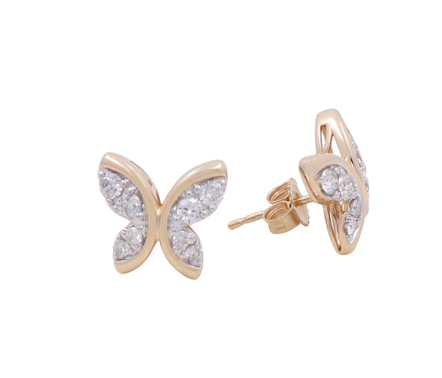 A close-up of a pair of luxurious butterfly-shaped stud earrings in 10K yellow gold with embedded clear gemstones from Miral Jewelry, exuding the elegance of diamonds.