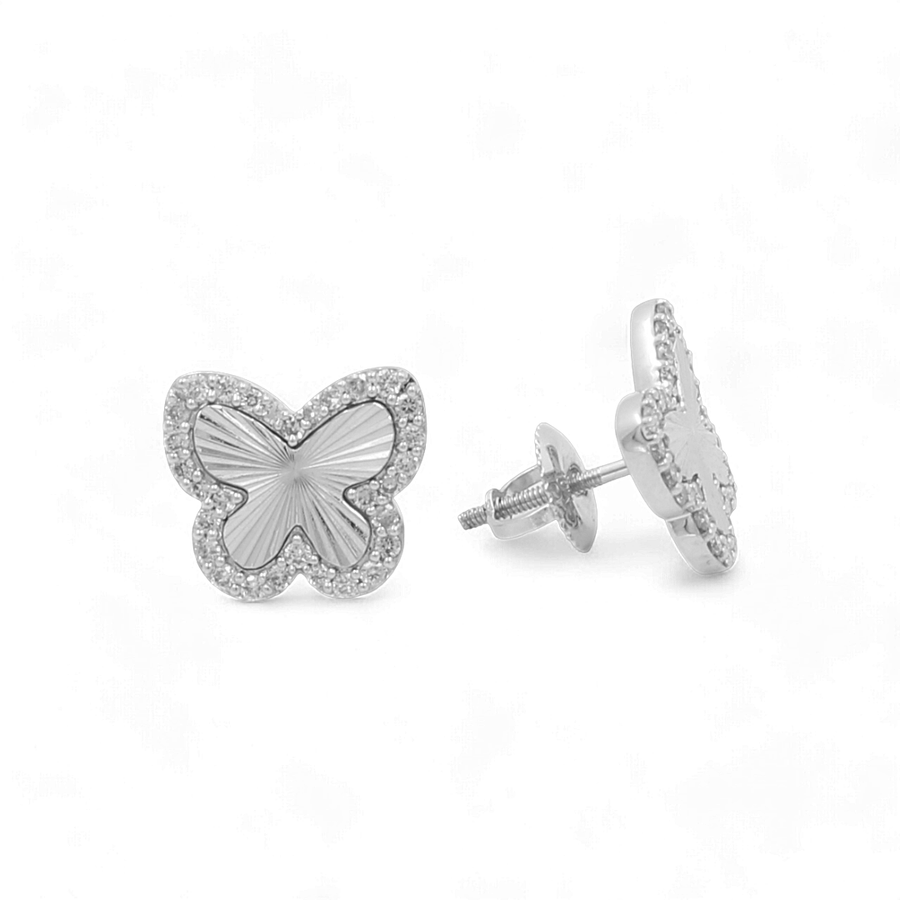 Discover the elegance found in our 10K White Gold Fashion Butterfly Diamond Women's Ring collection from Miral Jewelry, illustrated by a pair of butterfly-shaped stud earrings crafted from 10K gold. These earrings feature a textured center and a border of small stones, with one earring facing forward and the other shown from a side angle on a white background.