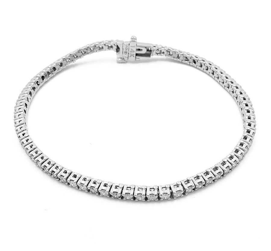 A close-up image of a thin, silver-toned women's 14k White Gold Diamond Tennis Bracelet 2.00Tw Round Diamonds from Miral Jewelry with a clasp. The bracelet features a consistent pattern of small, square segments connected together.