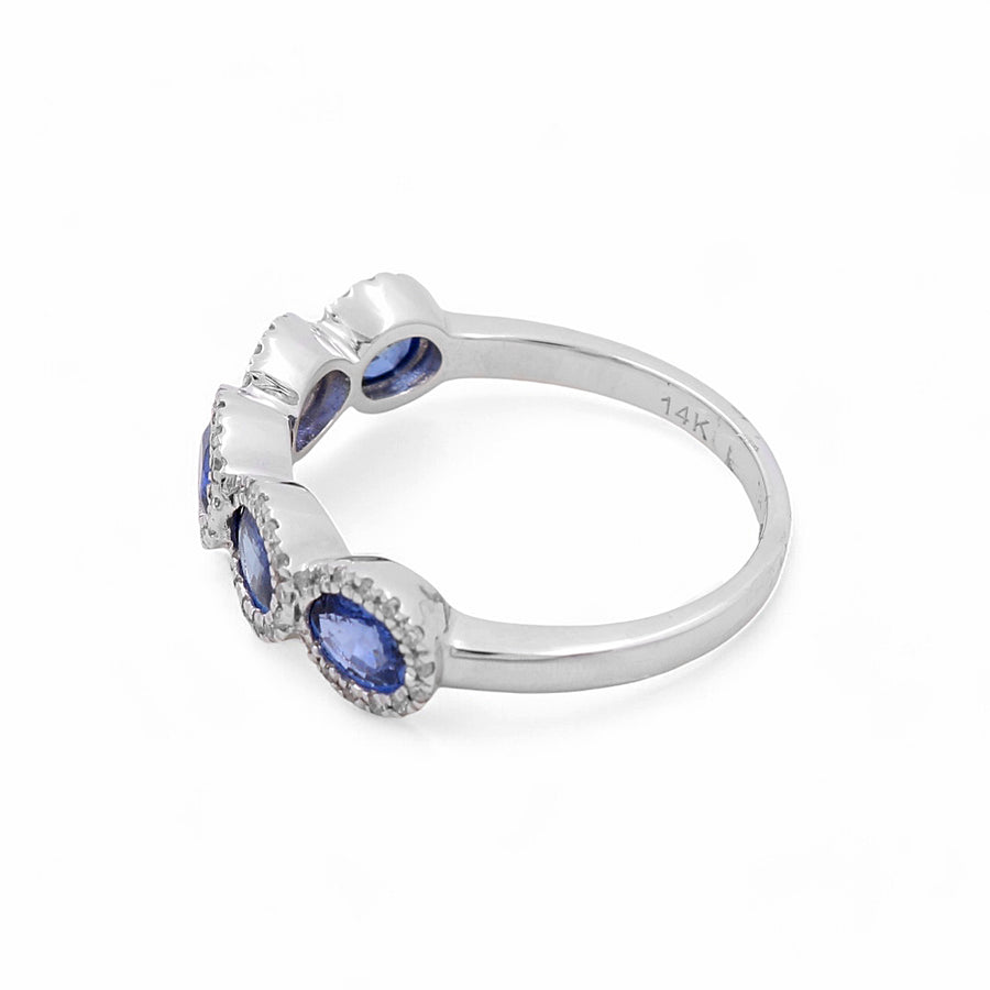 A 14K white gold women's ring from Miral Jewelry, featuring five blue sapphires set in a heart-shaped design, stamped with "14K" on the band.