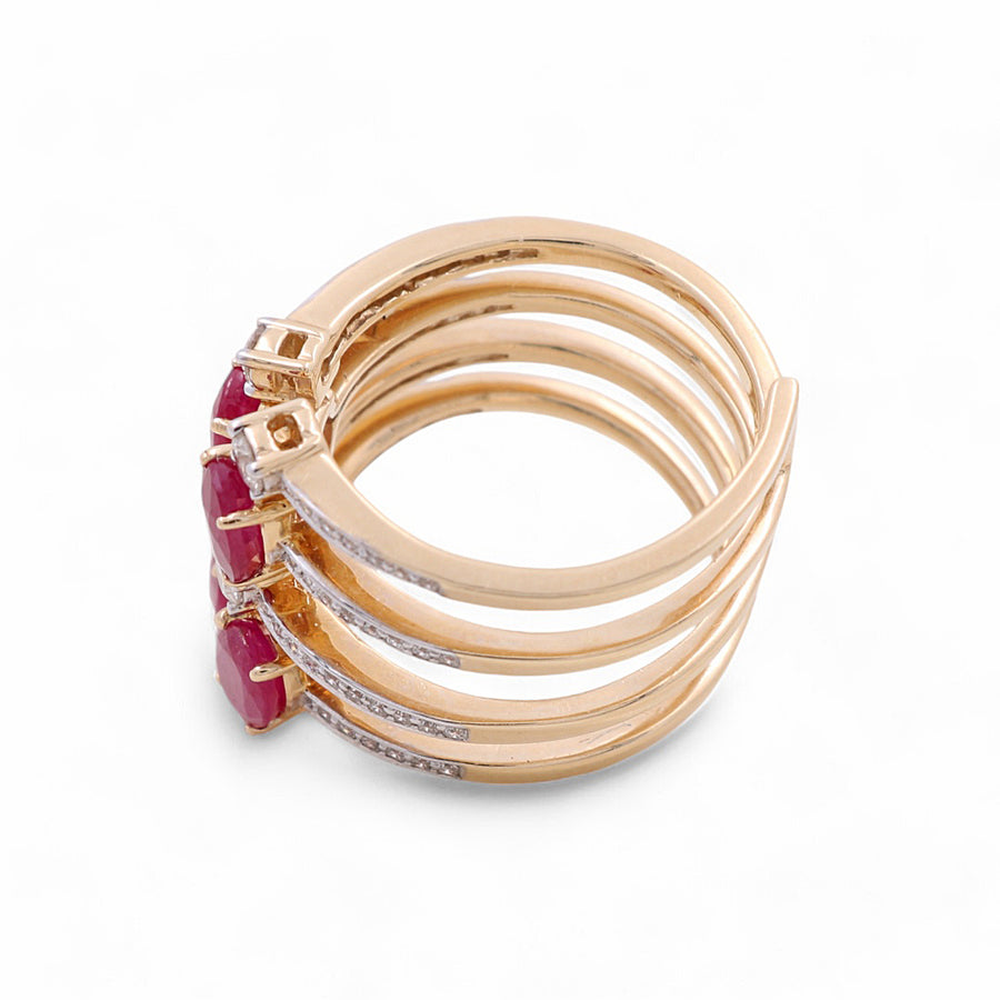 The Miral Jewelry 14K Yellow Gold Woman Fashion Ring with Diamonds and Ruby is a stunning multi-band piece, adorned with three polished red rubies and small diamonds on each band, all set against a white background.