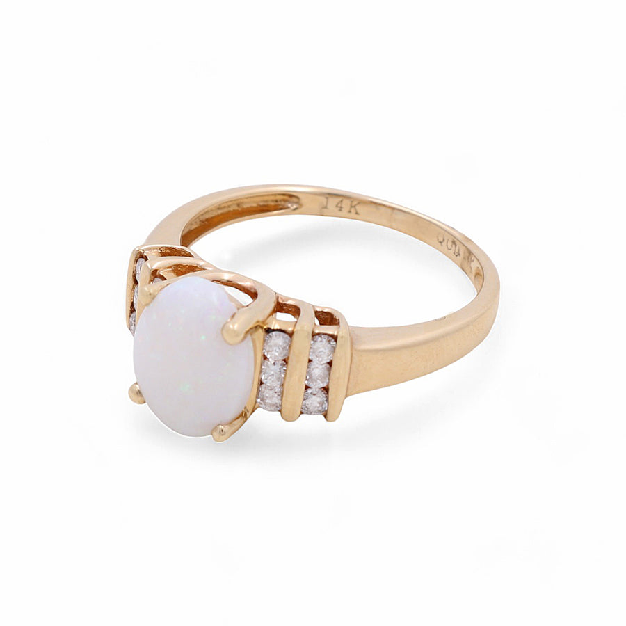 Crafted by Miral Jewelry, the 14K Yellow Gold Woman Fashion Ring flaunts an exquisite oval opal center stone, complemented by three small round-cut diamonds on either side.