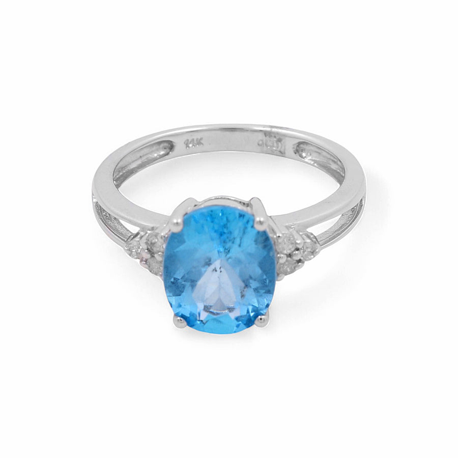 A stunning 14K white gold ring from Miral Jewelry, featuring an oval blue topaz in the center and flanked by small diamonds on either side, this piece embodies a contemporary design perfect for a diamond engagement ring.