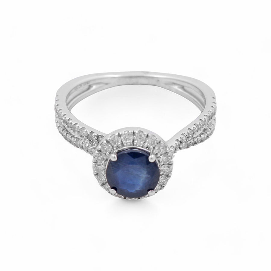 The 14K White Gold Woman Fashion Ring by Miral Jewelry showcases a captivating sapphire at the center, embellished with small clear diamonds along the band and the setting.